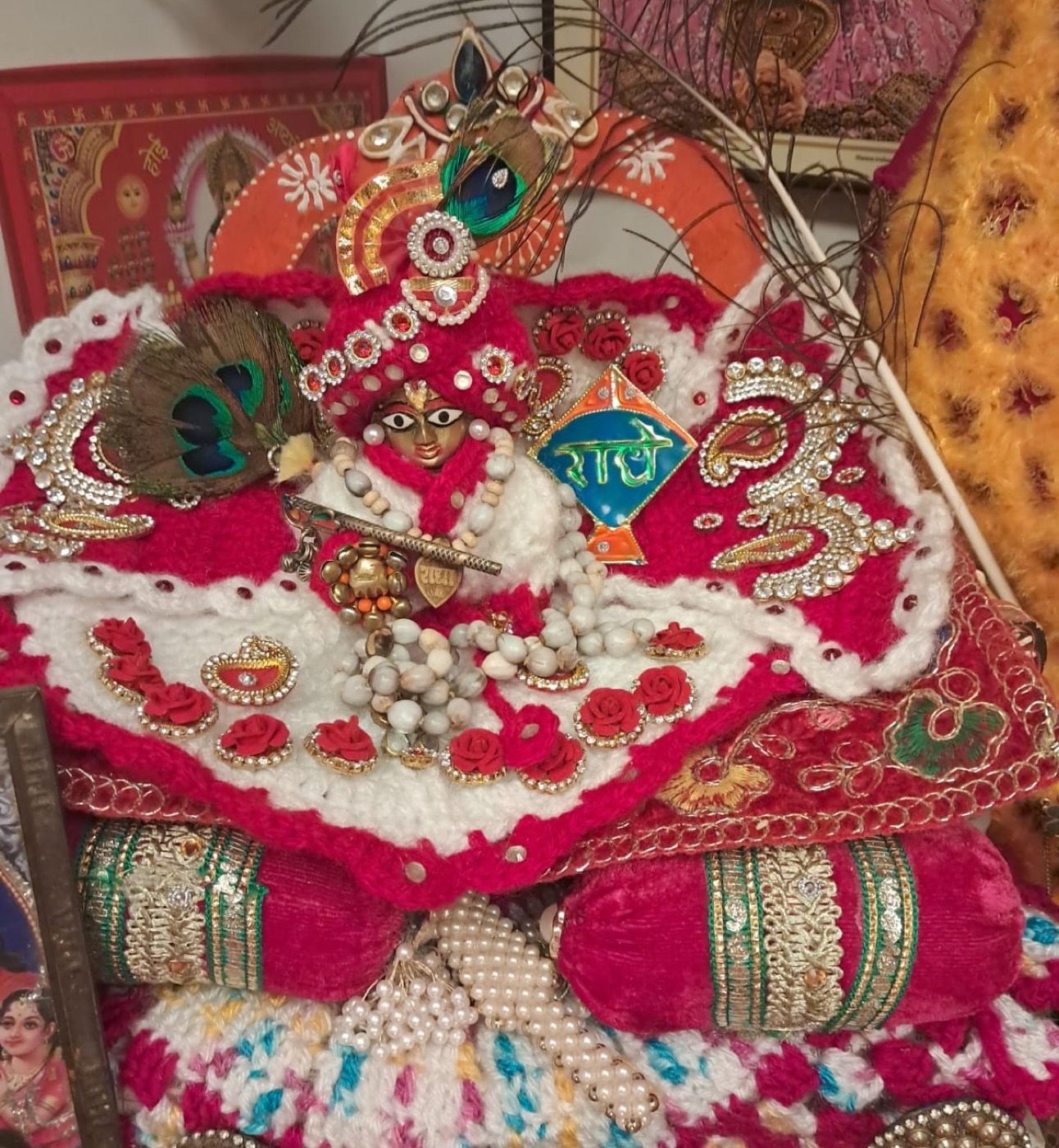A handmade crochet outfit and accessories made for a Kanhaji idol, richly decorated with pearls and peacock feathers