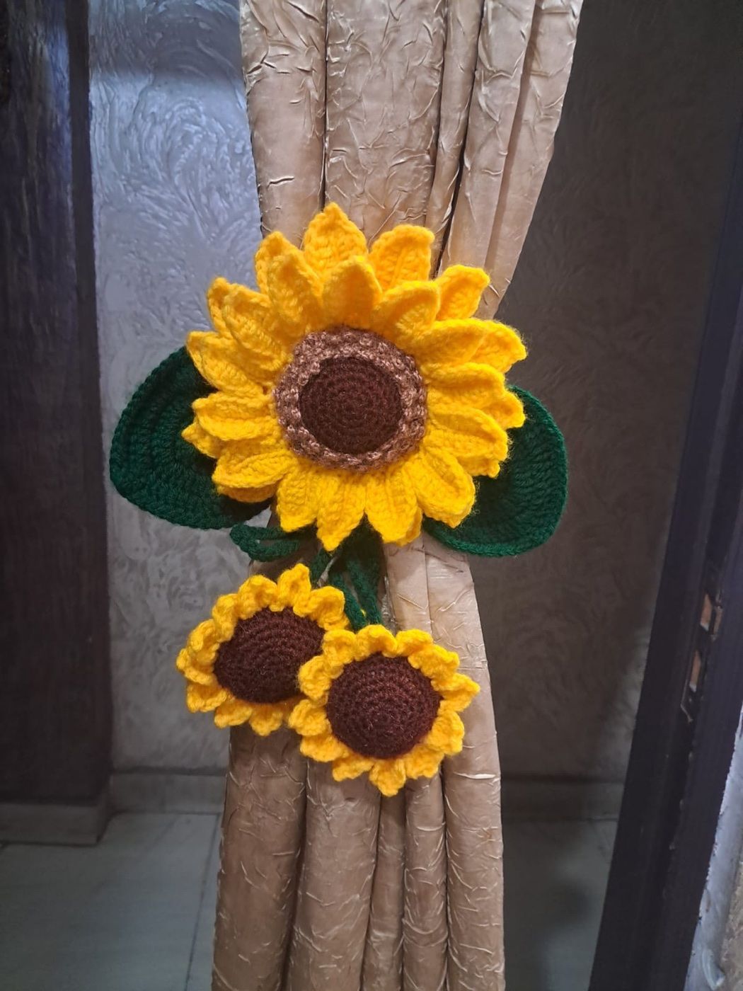 A finished handmade crochet sunflower curtain tie-back